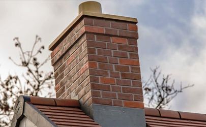 Brick chimney stack with lead flashing on a tiled roof